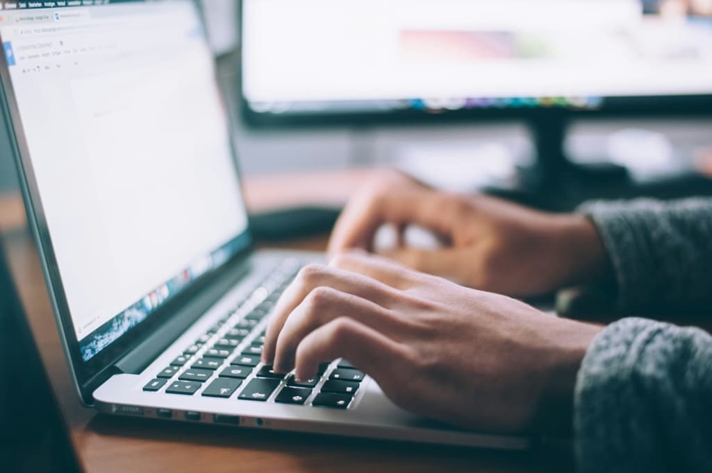 A person conducting a background check using their laptop