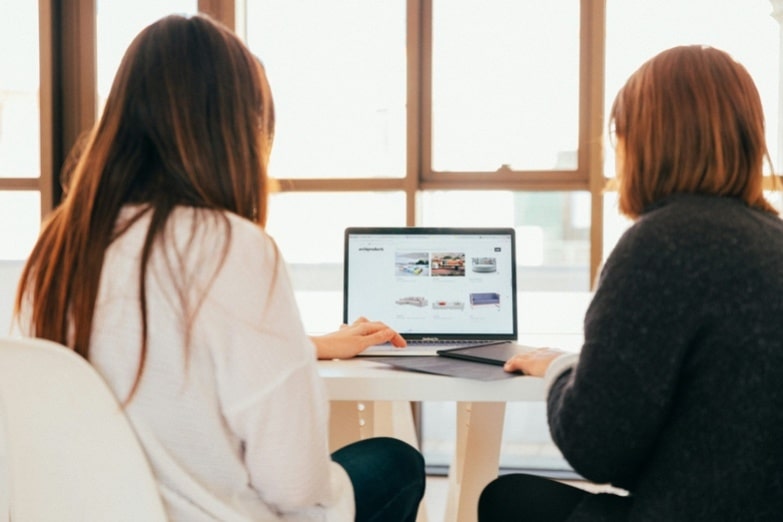 Two women working together on a laptop