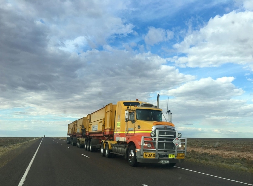 A yellow truck driving on the highway