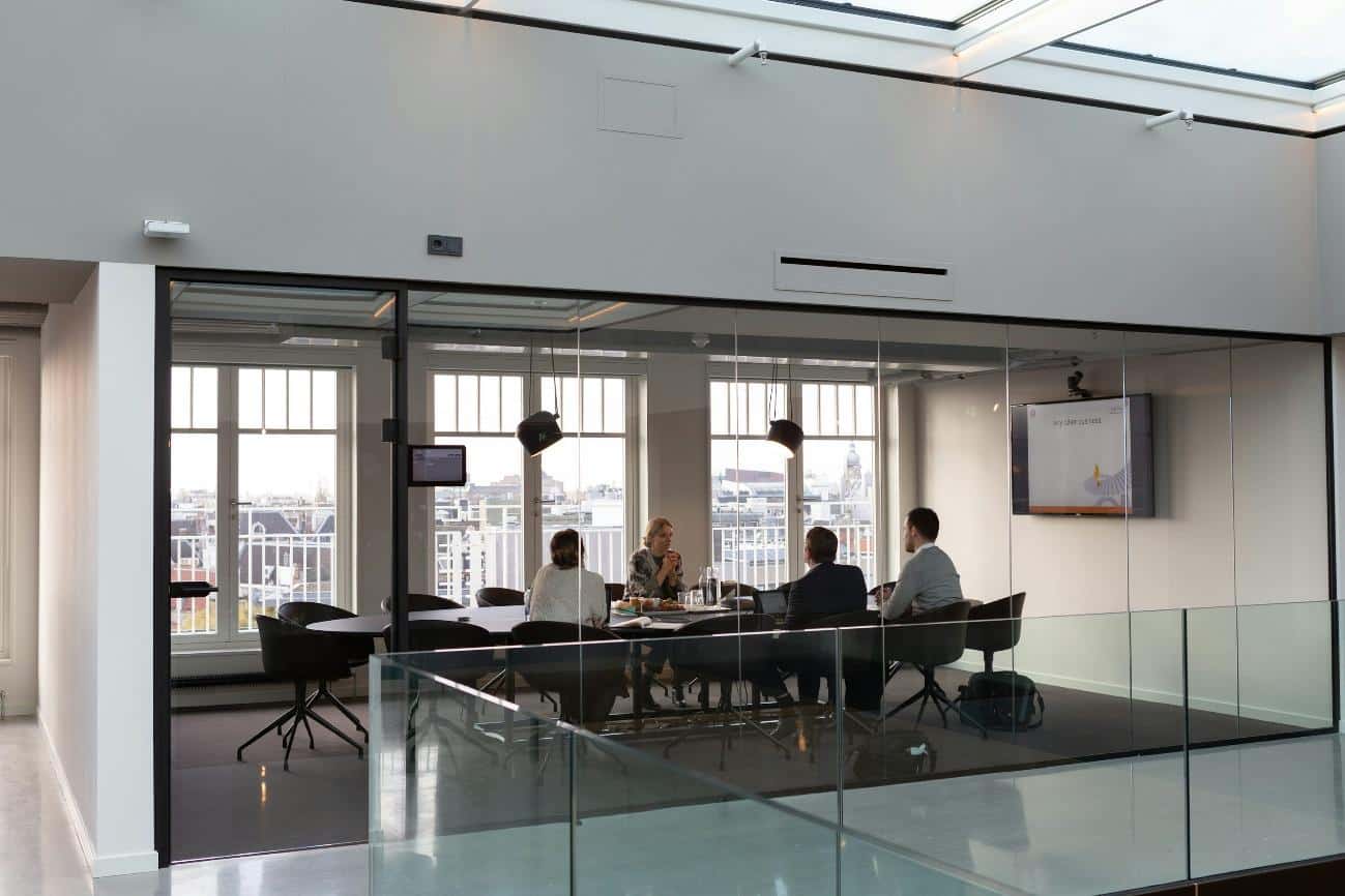 Business professionals discussing cybersecurity strategies in a modern conference room.