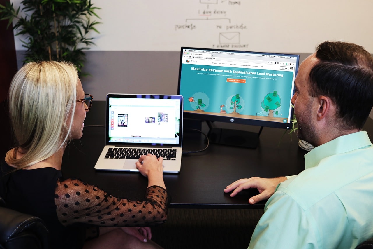 two people working on a computer.